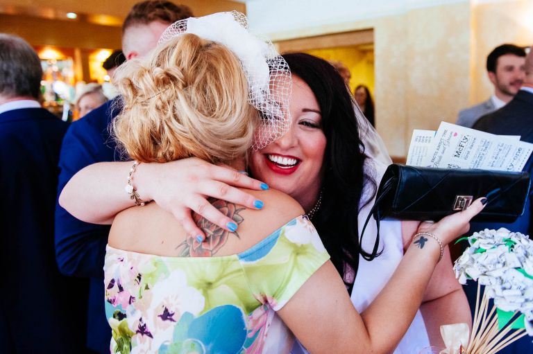 Bride gets a hug from a wedding guest
