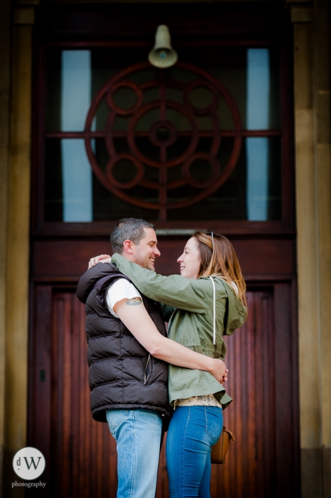 Couple holding each other in front of a door