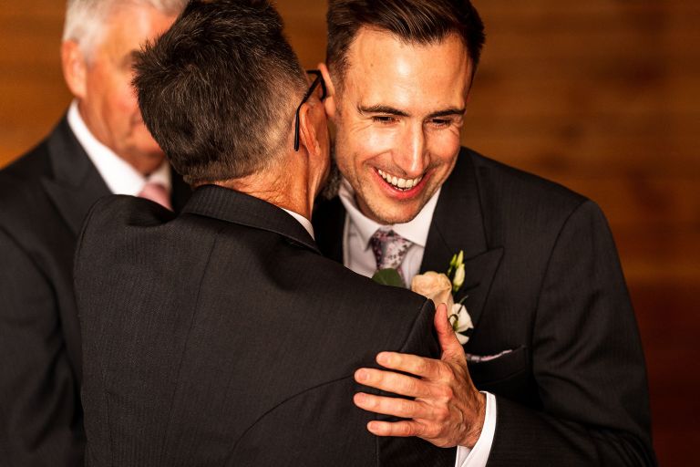 Groom hugs father of the bride