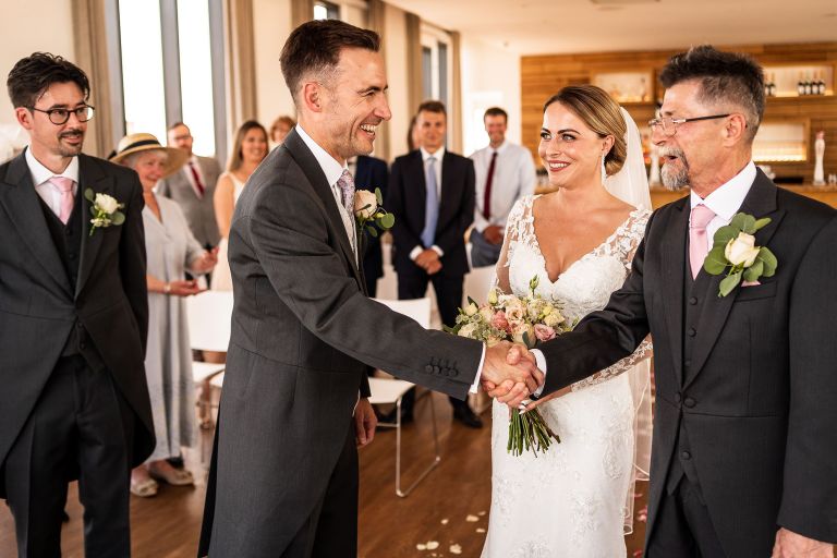 Groom shakes hands with father of the bride