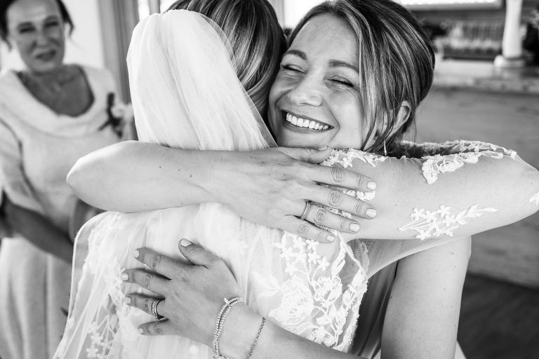 Wedding guest hugs bride
