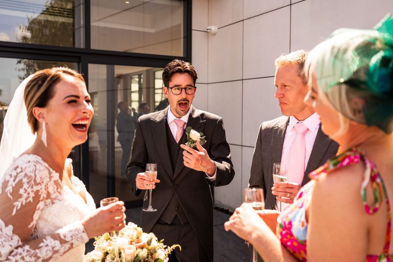 Best man tells a joke to bride and guests