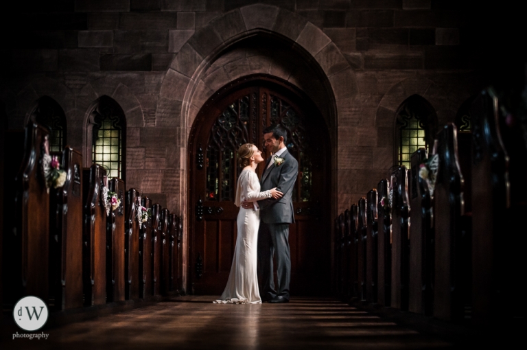 Bride and groom face each other by door of church