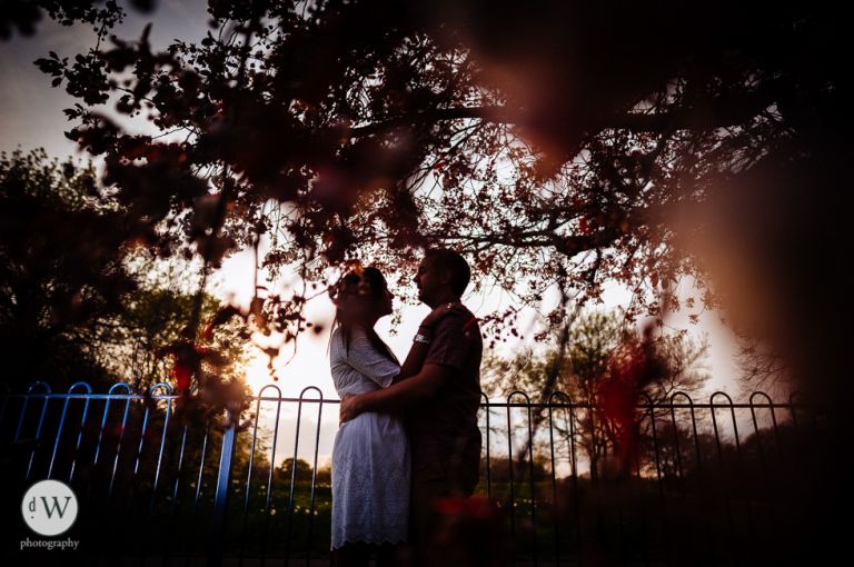 couple holding each other under a tree