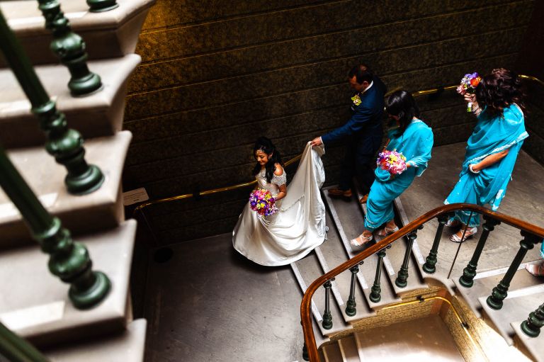 Bride walks down the stairs with groom and bridesmaids