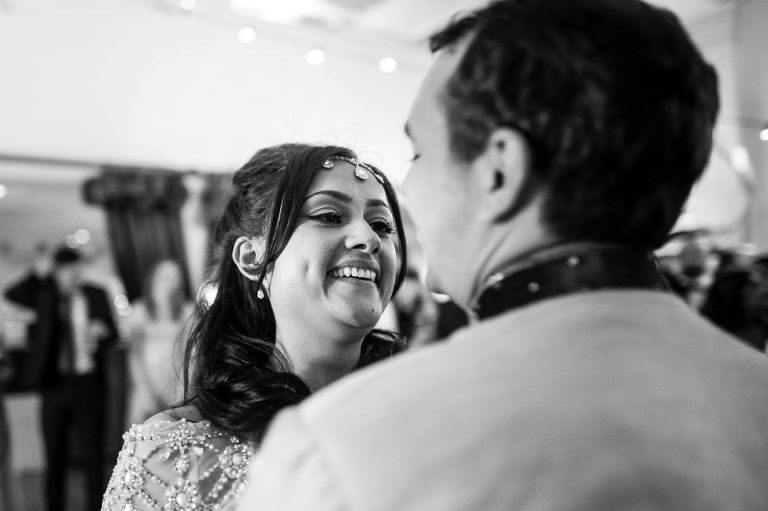 Bride smiles at the groom during the first dance