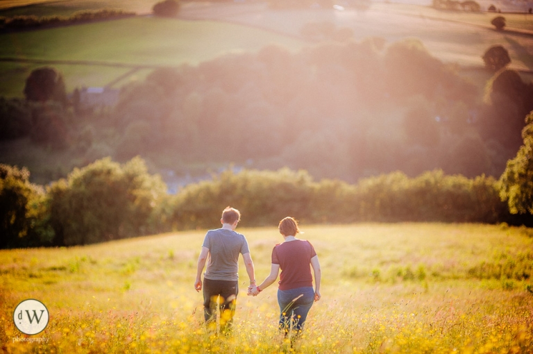 Couple walking holding hands in a meadow