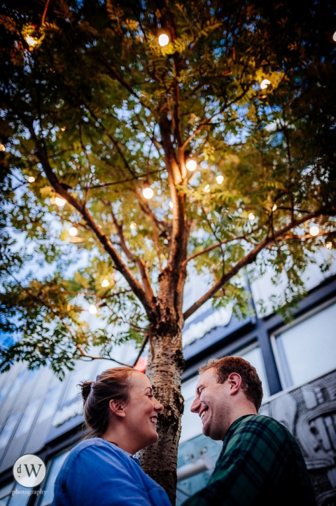 Couple share a joke under a tree