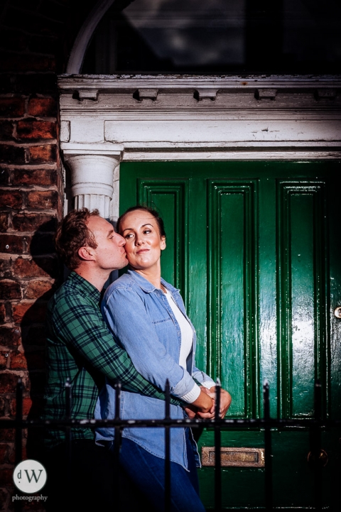Man kissing woman in front of a door
