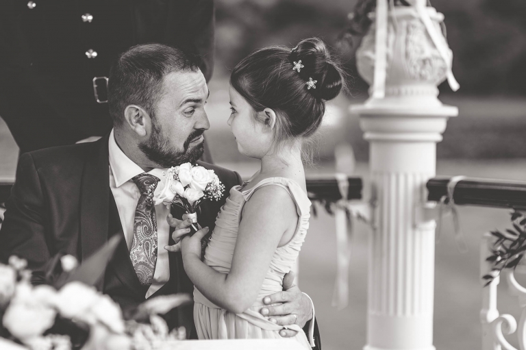 Flower girl and groom smile at each other