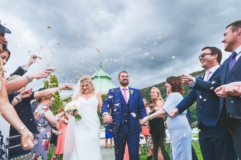 Guests throw confetti over the newlyweds