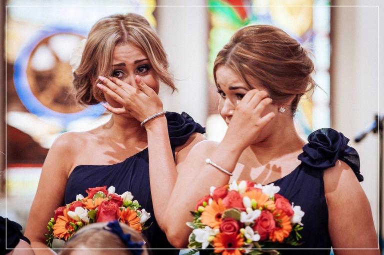 bridesmaids crying as bride walks up the aisle in church