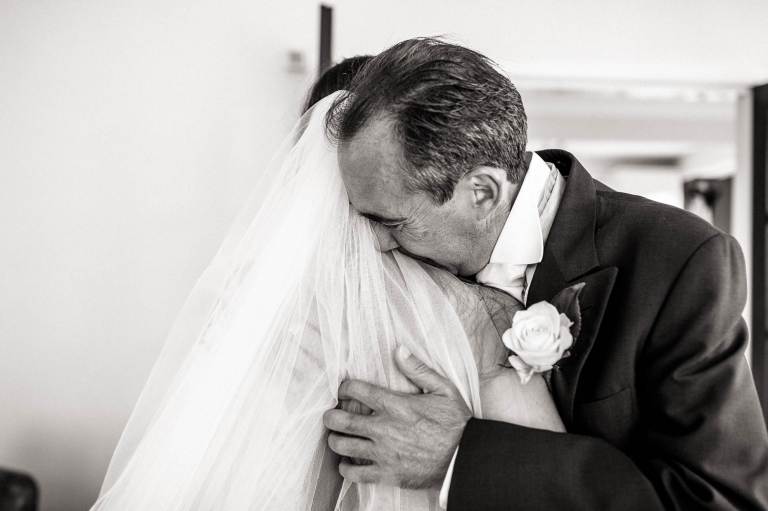 dad hugs the bride as he sees her in her dress for the first time