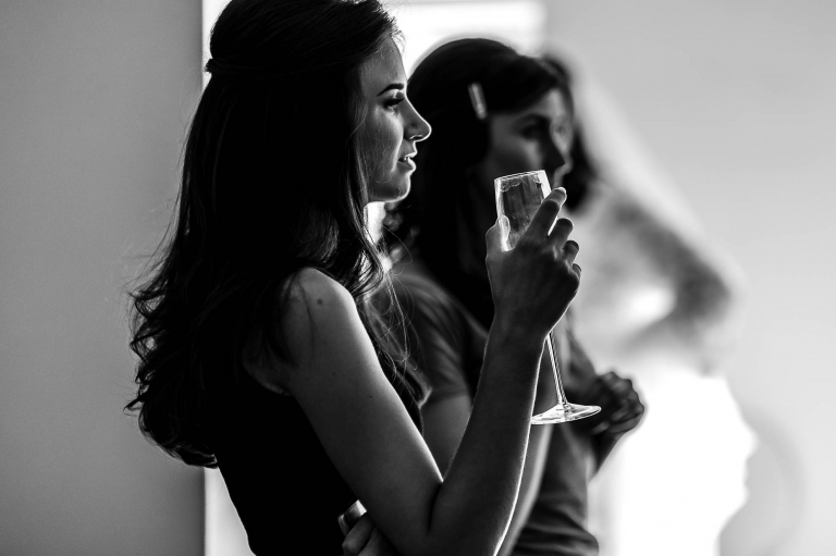 Bridesmaid enjoys a glass of champagne