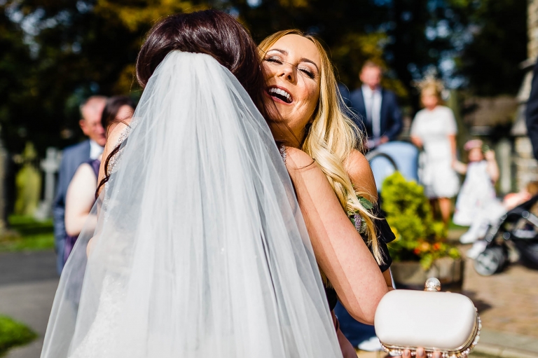 a big hug for the bride from a guest