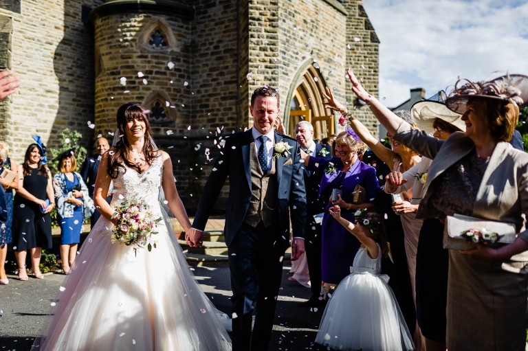 bride and groom have confetti thrown over them