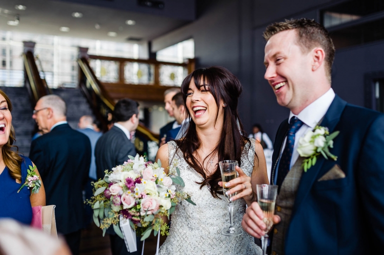 Bride and groom share a joke with guests