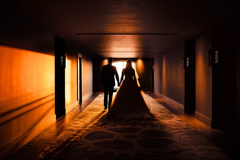 Bride and groom walk down corridor