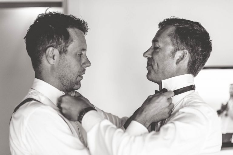 Same sex couple adjusting each others neckties