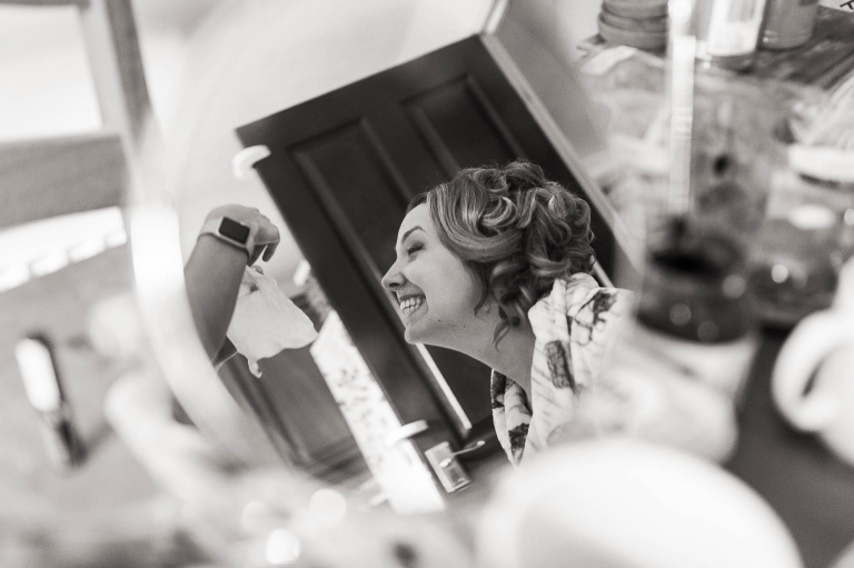Bridesmaid reflection in mirror as she gets ready for the big day