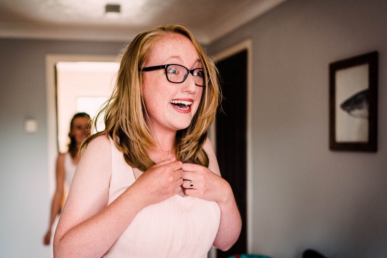 Bridesmaid is thrilled to see the bride in her dress for the first time