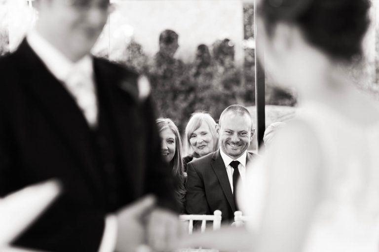 Guests smile at the bride and groom during the cremony