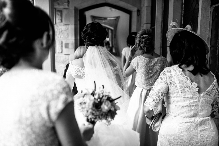 bride walks into West Tower with her bridesmaids