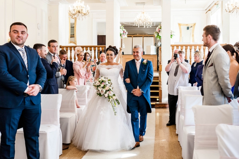 bride walks up the aisle with her father
