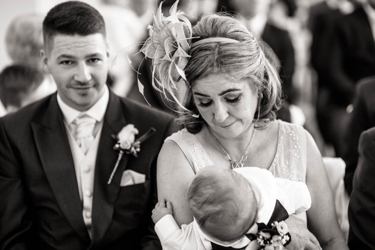 mother of the bride looks lovingly at grandson