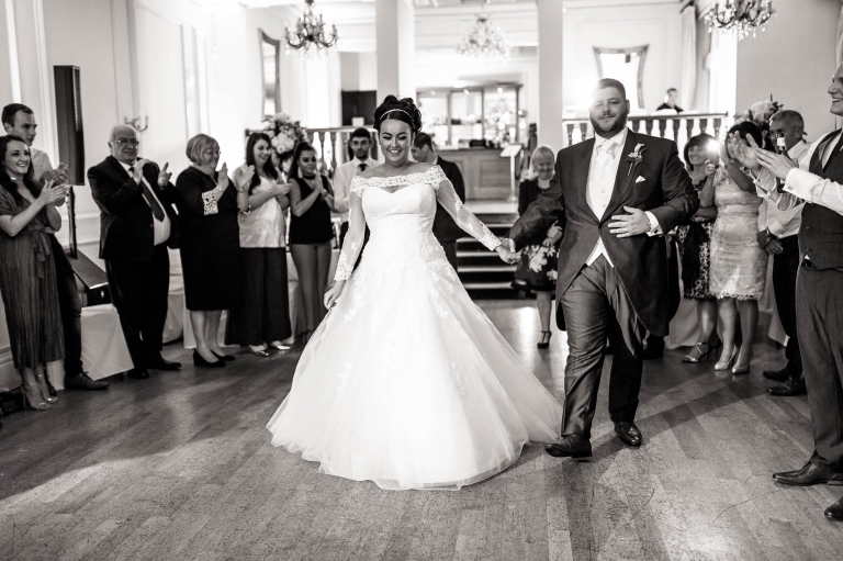 bride and groom walk onto the dance floor for first dance