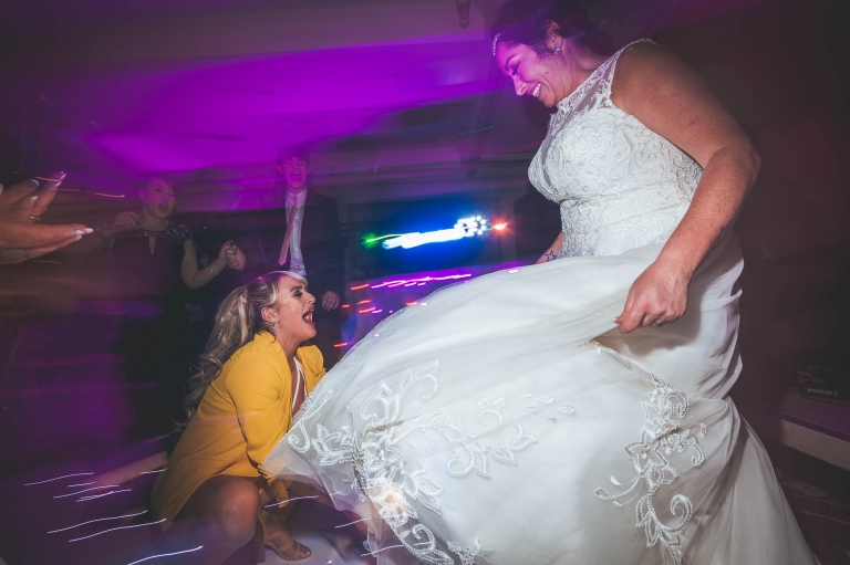 guest adjusts brides dress