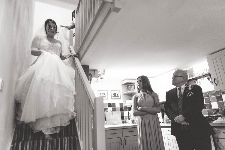 bride walks down stairs in her wedding dress