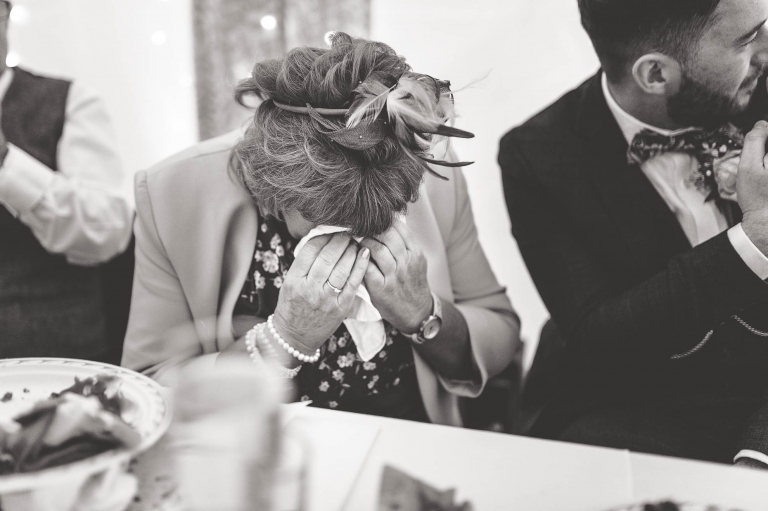 Mother of the groom wipes away a tear