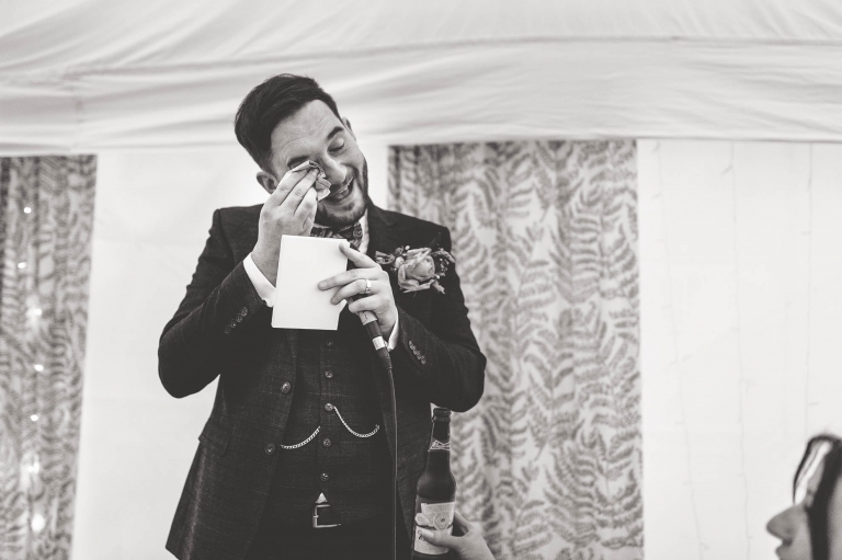 Groom wipes away a tear as he gives his speech