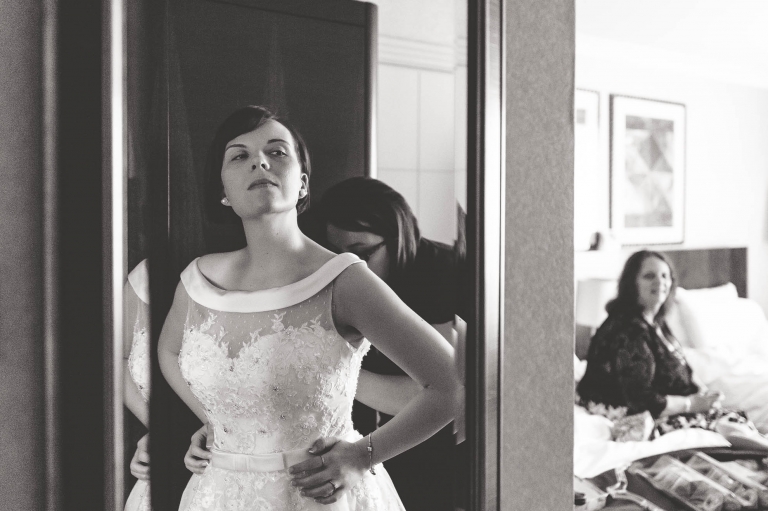 bride with her dress on looking in mirror