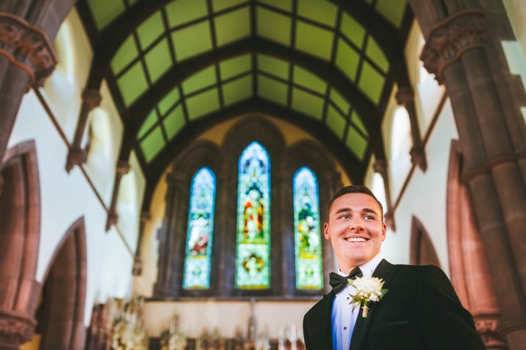 Groom smiles as he waits for his bride