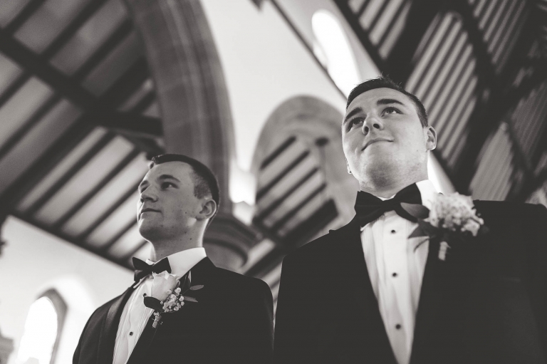 Groom and best man wait for bride to walk up aisle