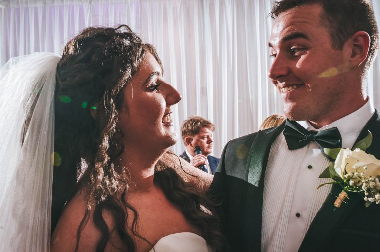 Bride and groom smile at each other during first dance
