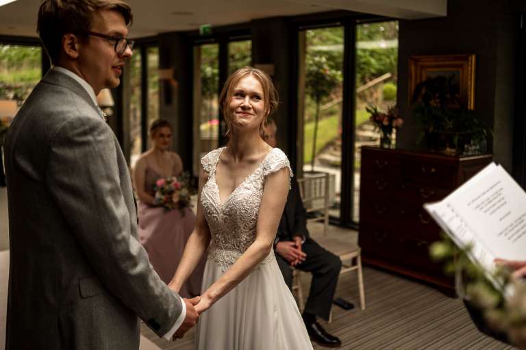 bride and groom smile at registrar