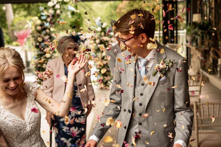 Bride and groom laugh during the confetti throw