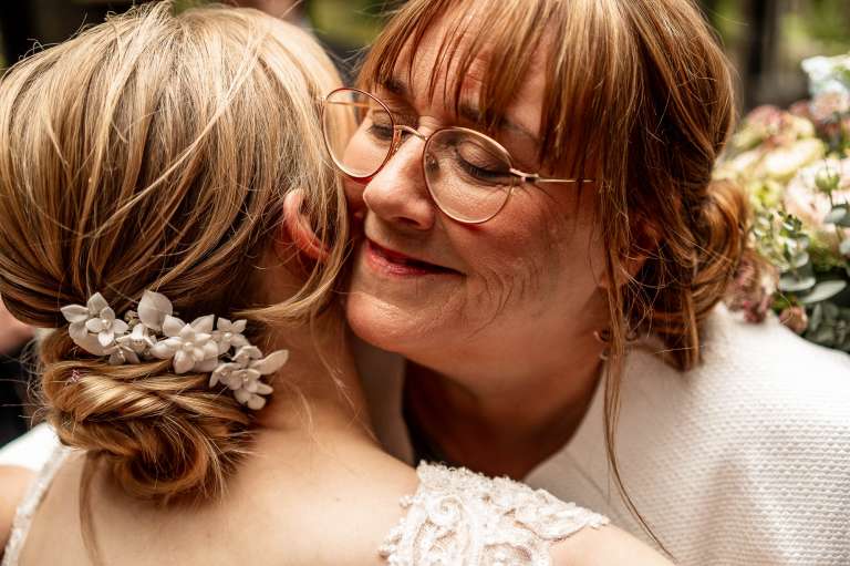 Mother of the bride hugs the bride
