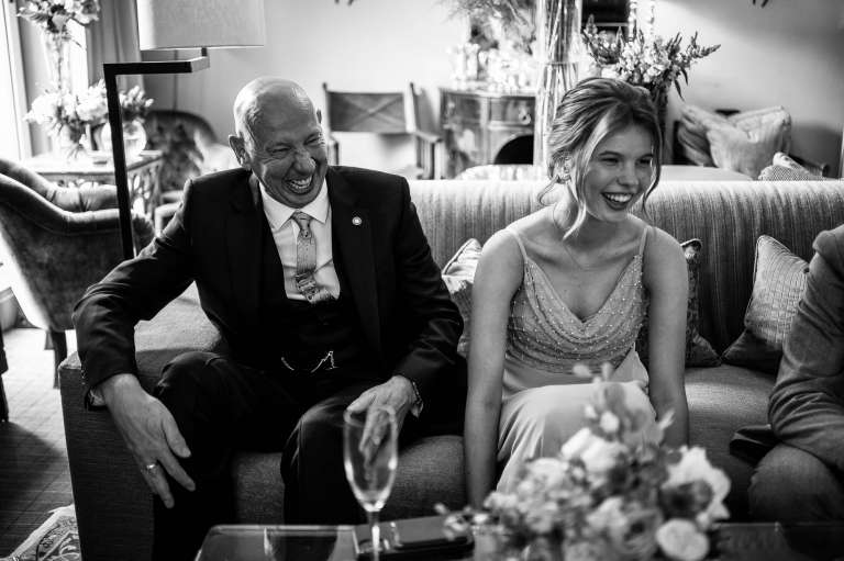 Father of the bride and bridesmaid share a joke