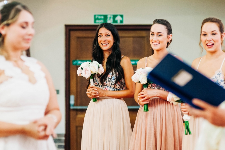 Bridesmaids smile during the ceremony