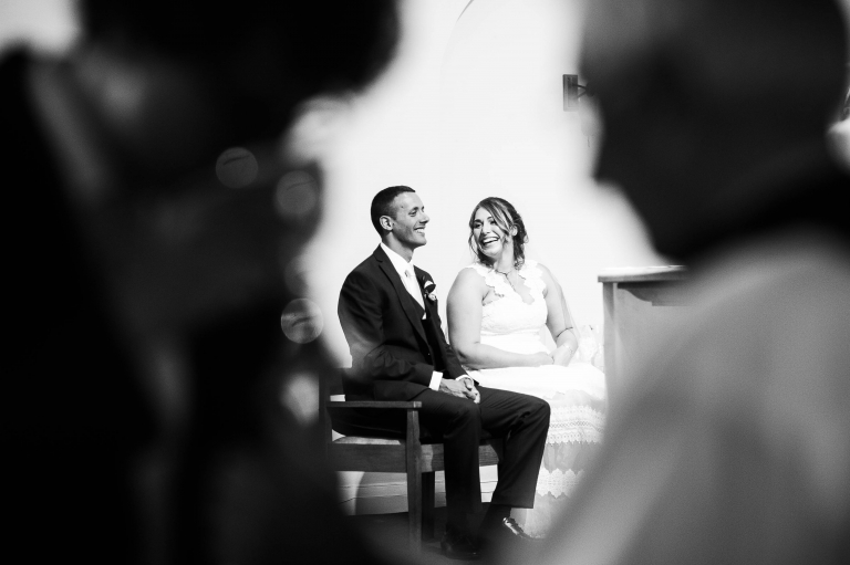 Bride and groom share a joke during communion