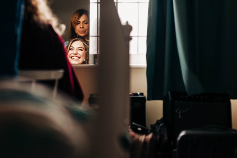 Bride laughs as she has her hair done