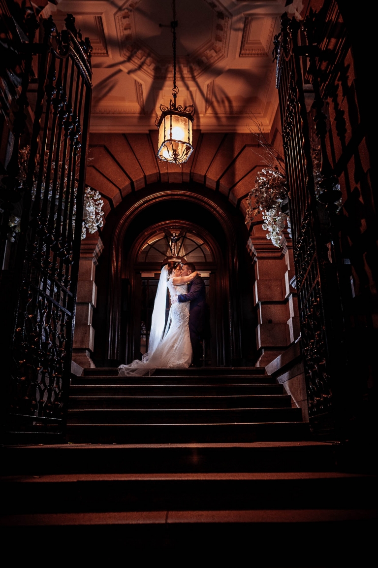 Bride and groom kiss on the stairs of 30 James street