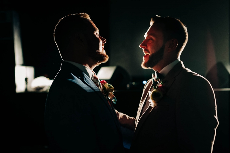 Same sex couple smile together during first dance