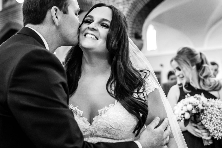 Groom gives the bride a kiss on the cheek