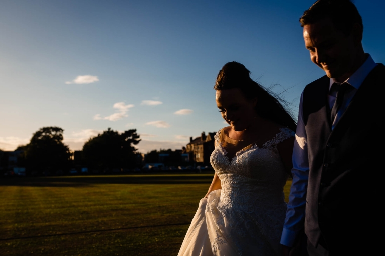 Bride and groom walk in the sunset