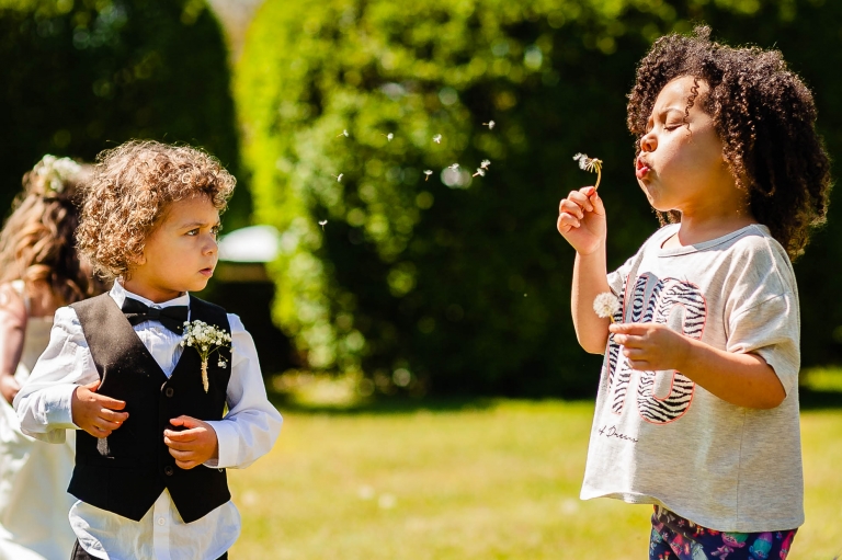 Kids playing with dandelions before the wedding ceremony